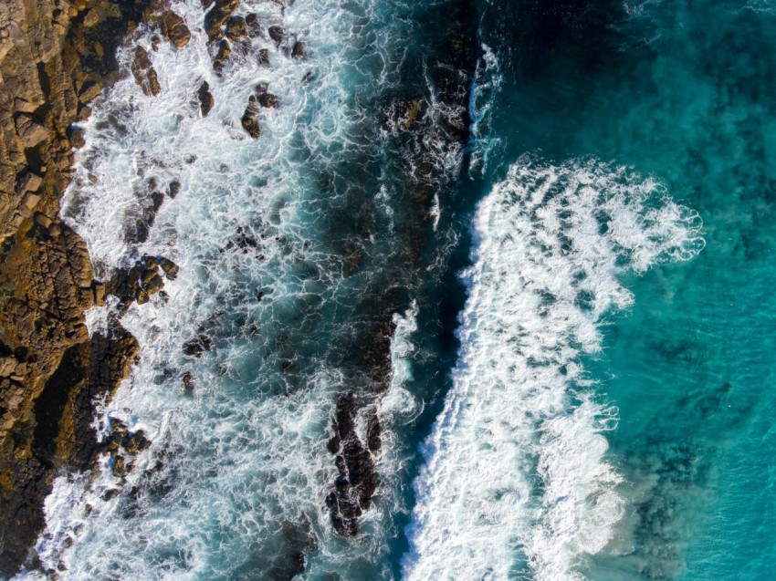 birds eye view of raging water waves against rock