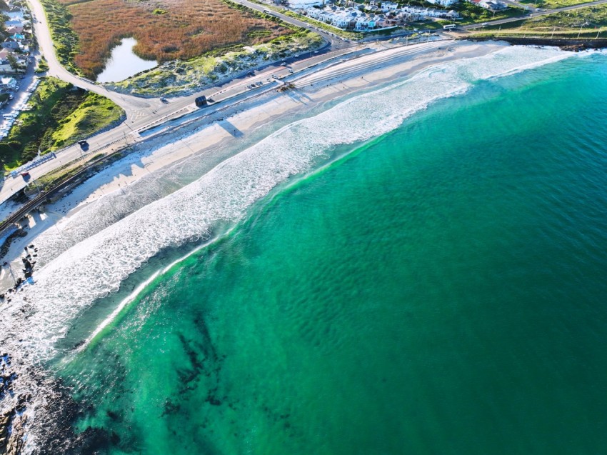 an aerial view of a beach and a highway