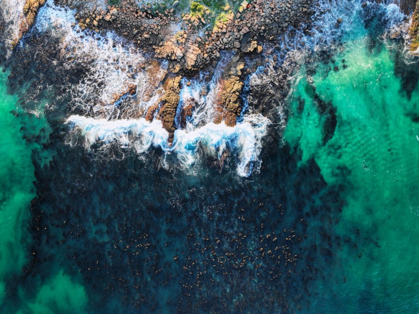 a birds eye view of the ocean and rocks