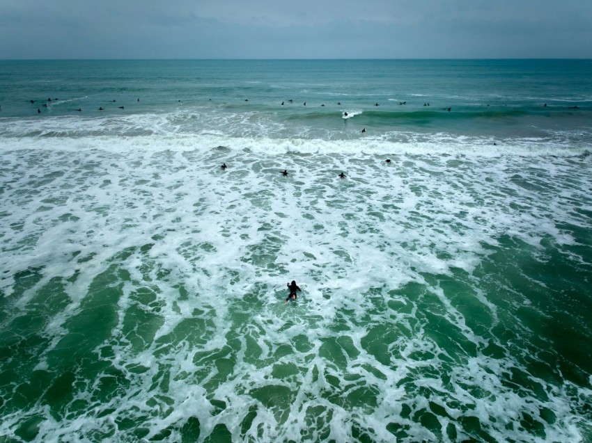 a man riding a surfboard on top of a wave in the ocean