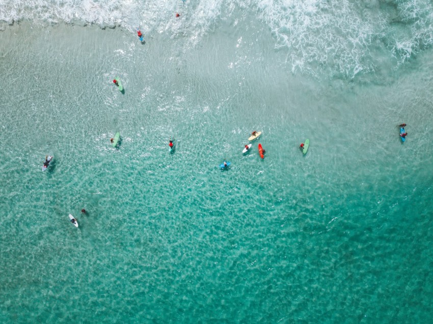 people surfing on sea waves during daytime