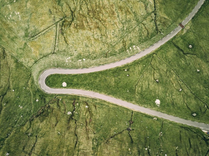 an aerial view of a winding road in the countryside