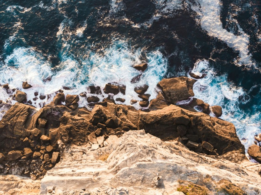 brown rocky shore with ocean waves during daytime