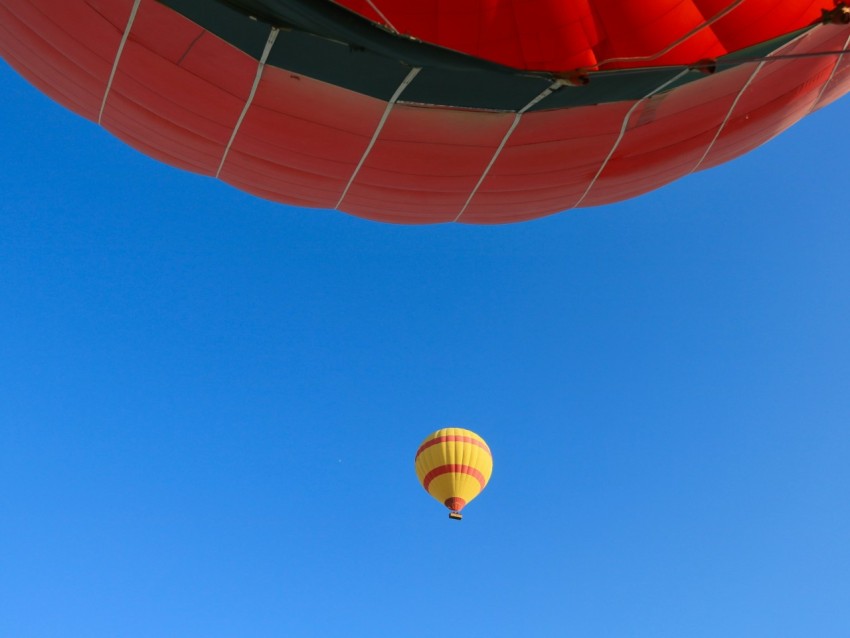 a hot air balloon flying through a blue sky