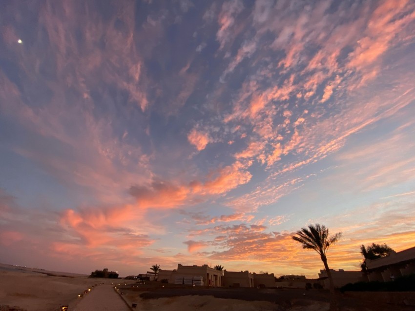 a sunset view of the sky over a beach