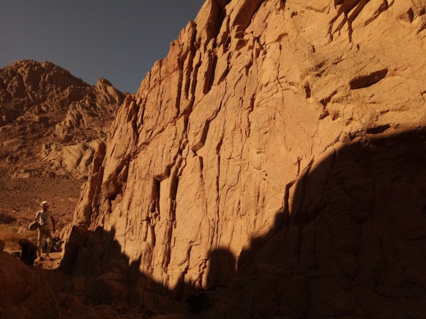 a man standing in the shadow of a mountain