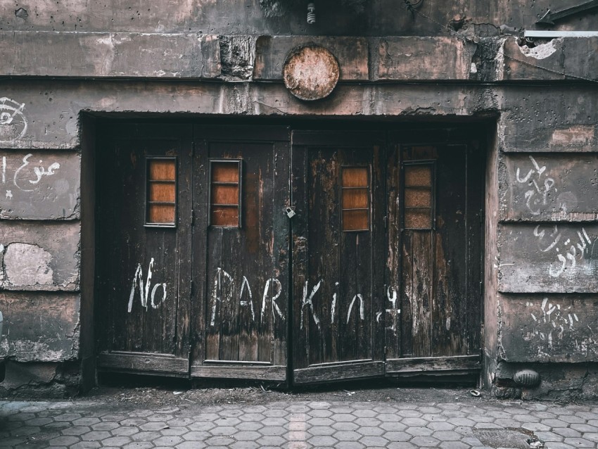 two wooden doors with graffiti written on them