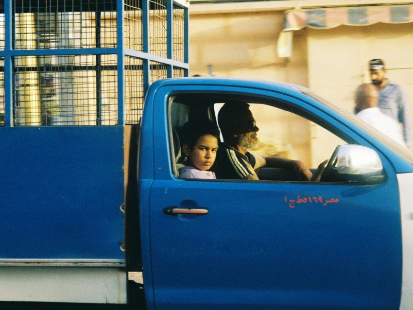 woman in blue crew cab pickup truck