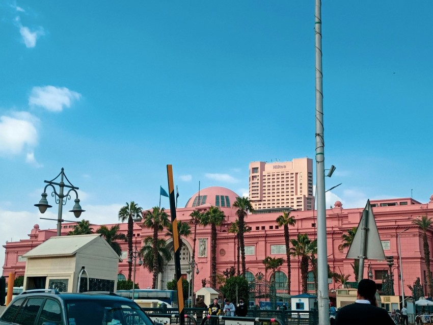 a pink building with a flag pole 1JH_Zj