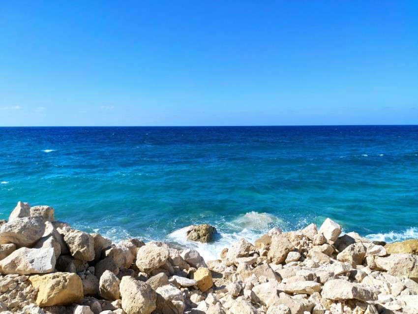 a rocky beach with blue water