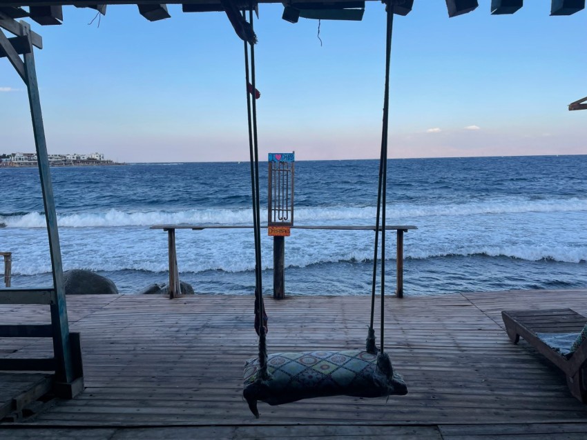 a wooden dock with two swings on it