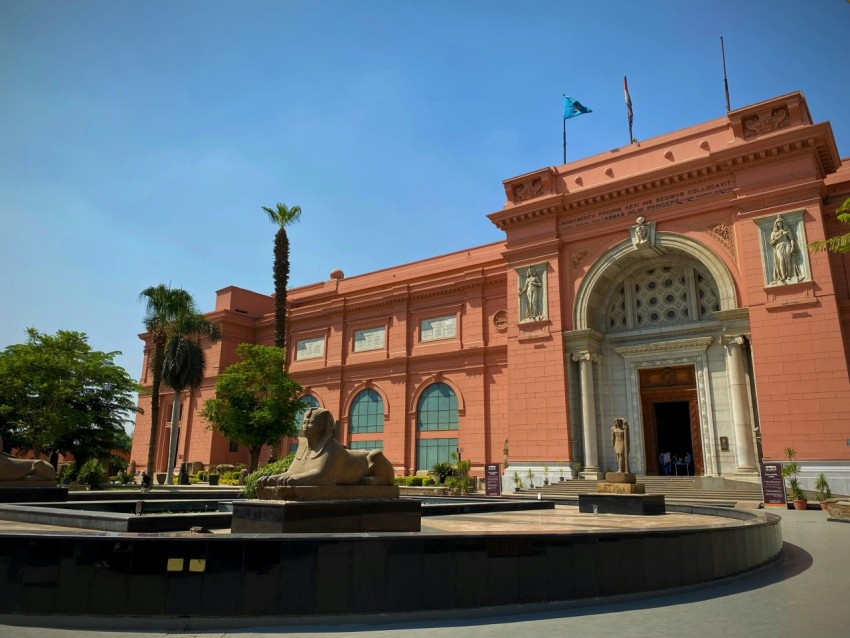 a large building with a fountain in front of it Bm