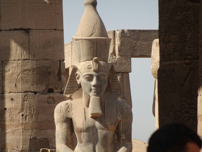 a statue of an egyptian god in front of a building