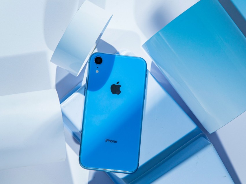 a blue iphone sitting on top of a white table