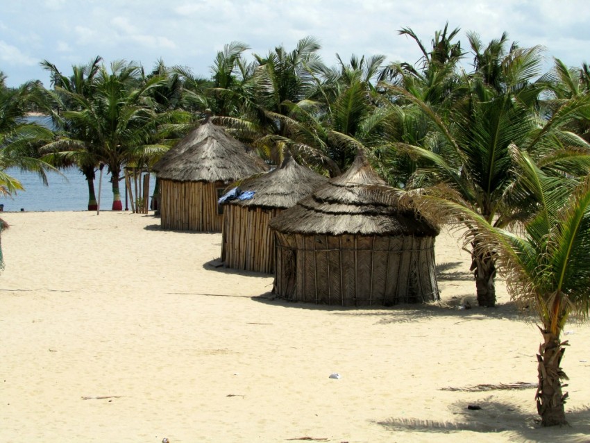 brown wooden hut on white sand during daytime