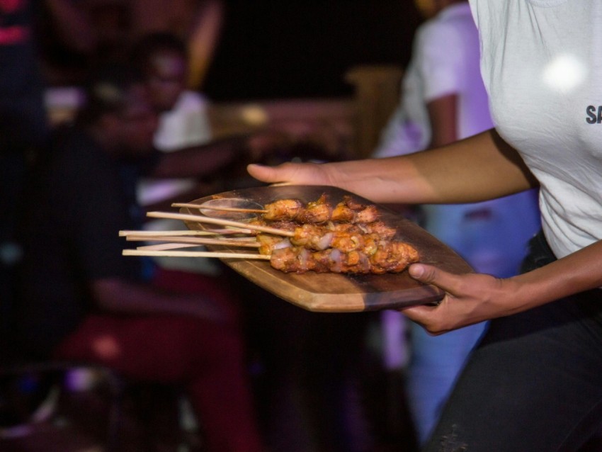 person in white shirt holding brown wooden fork