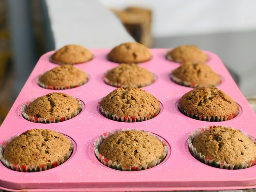 a pink tray filled with muffins on top of a table