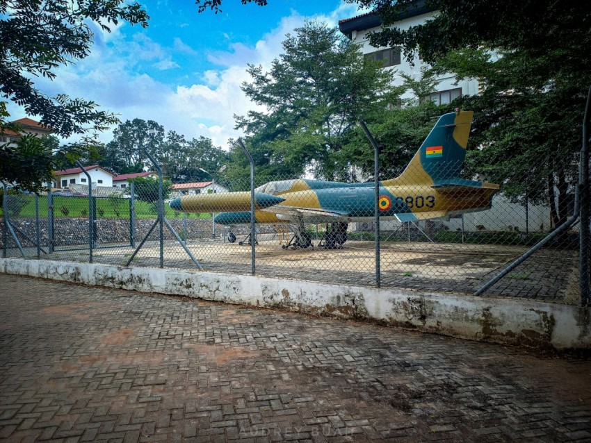 a fenced in area with two airplanes on display