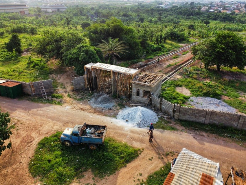 a truck parked next to a building on a dirt road