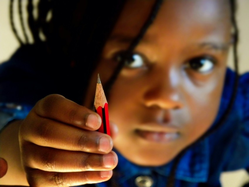 girl in blue shirt holding red pencil