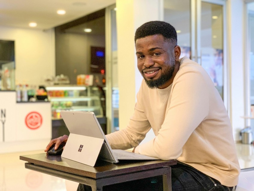 a man sitting at a table with a laptop AN