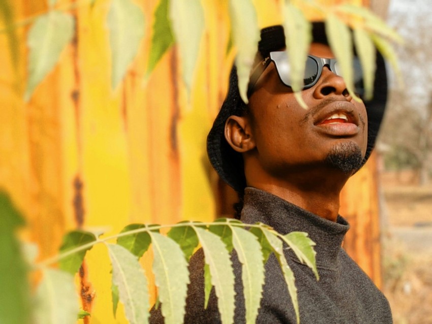 a man wearing sunglasses and a black hat