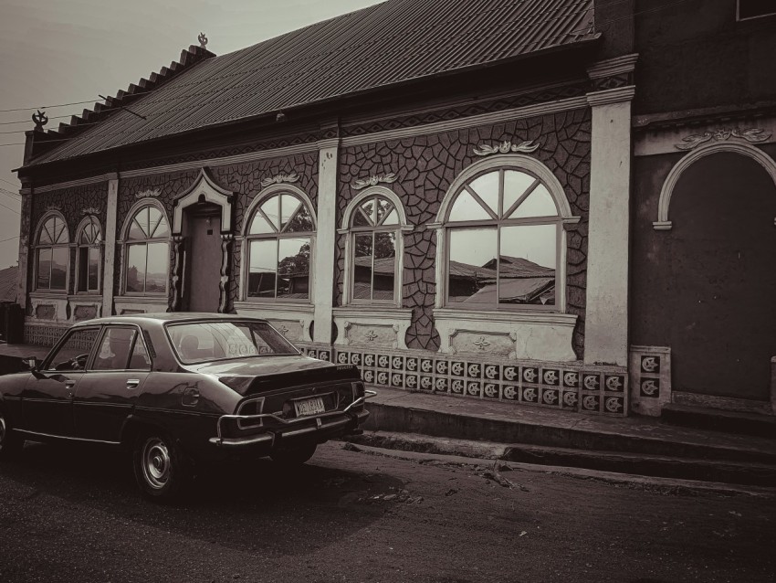 a car parked in front of a building frzezHE