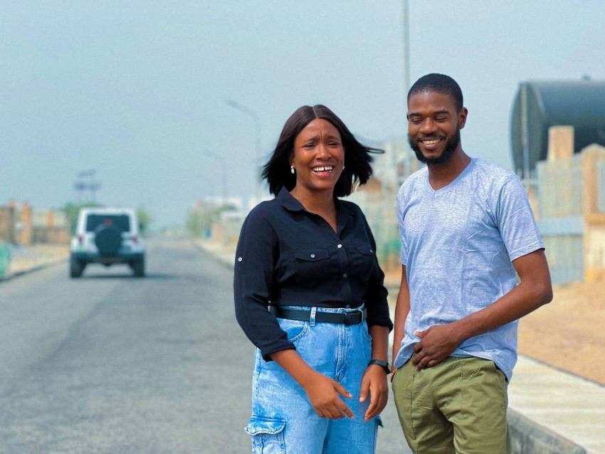 a man and a woman standing on the side of a road