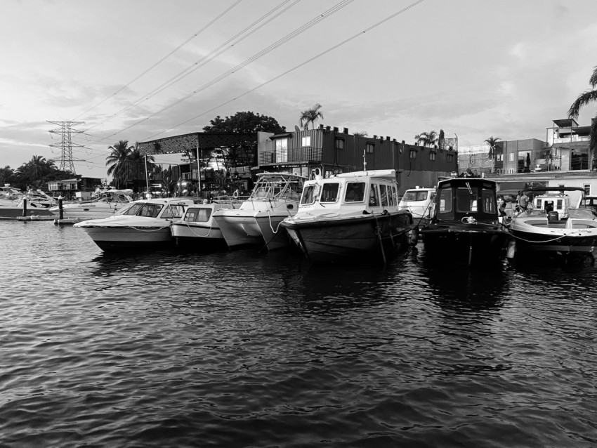 a black and white photo of several boats in the water