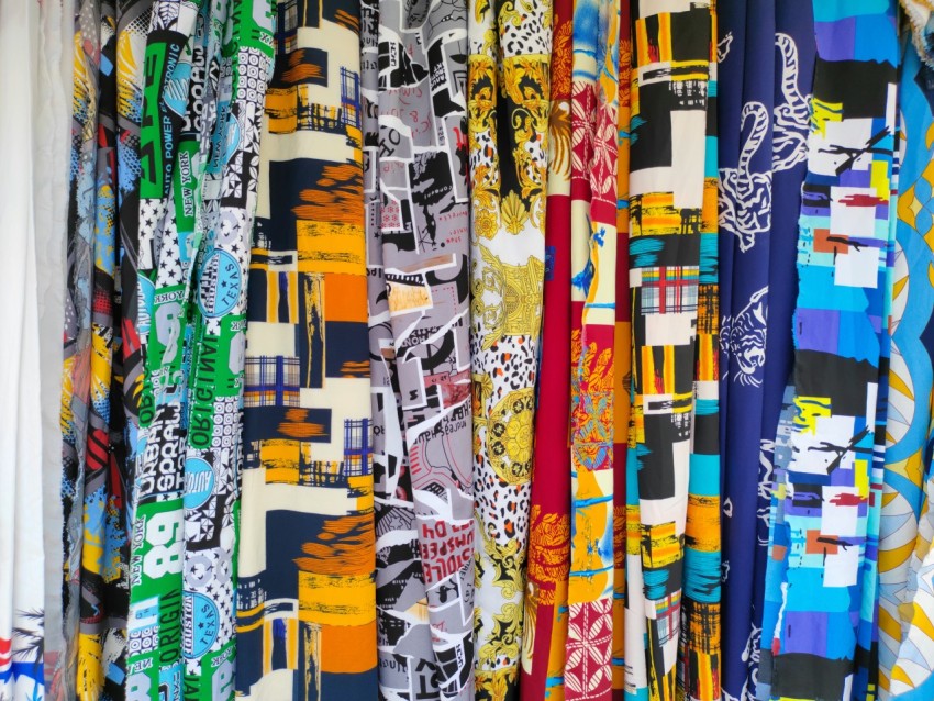 a bunch of different colored ties hanging on a wall