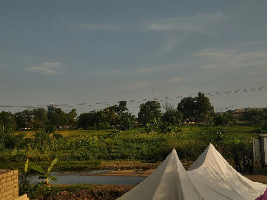 a large white tent sitting next to a lush green field