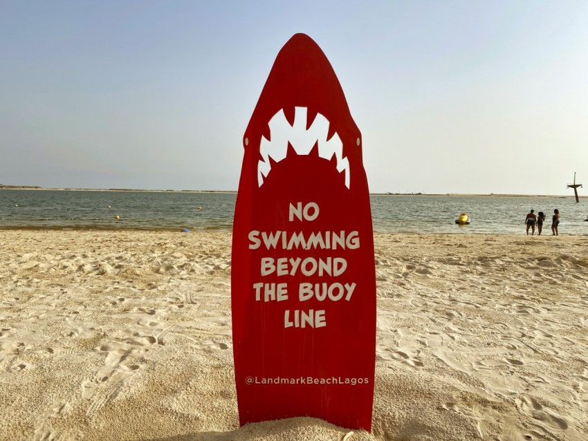 red and white beach signage on beach during daytime ESVBJM