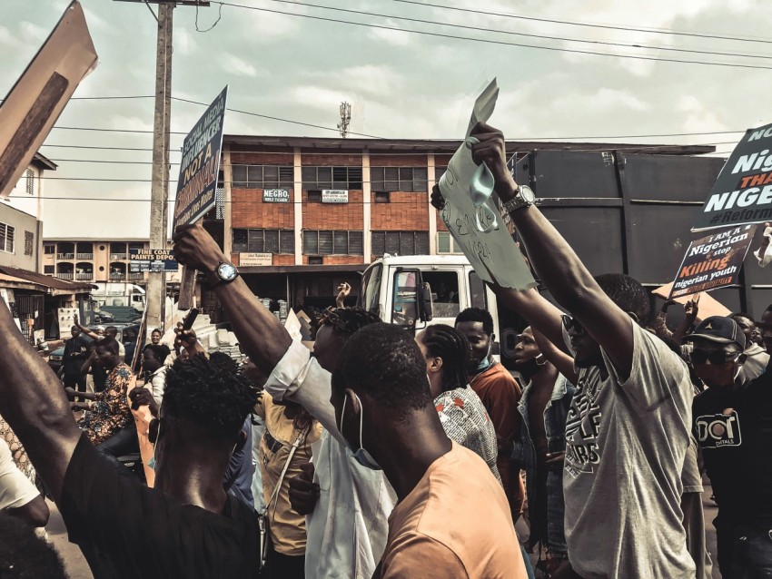 people standing and raising their hands during daytime qSoCo