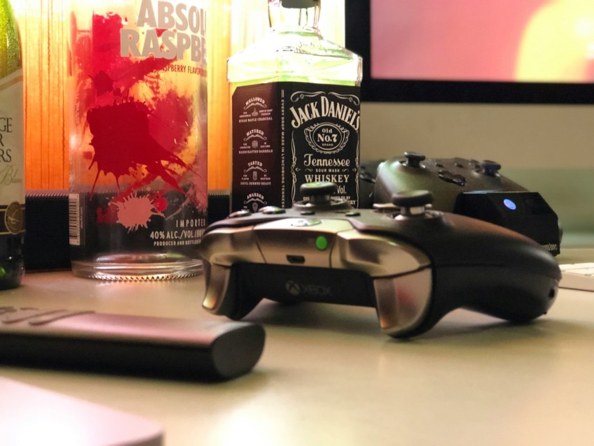 black handheld controller near black remote control on white surface