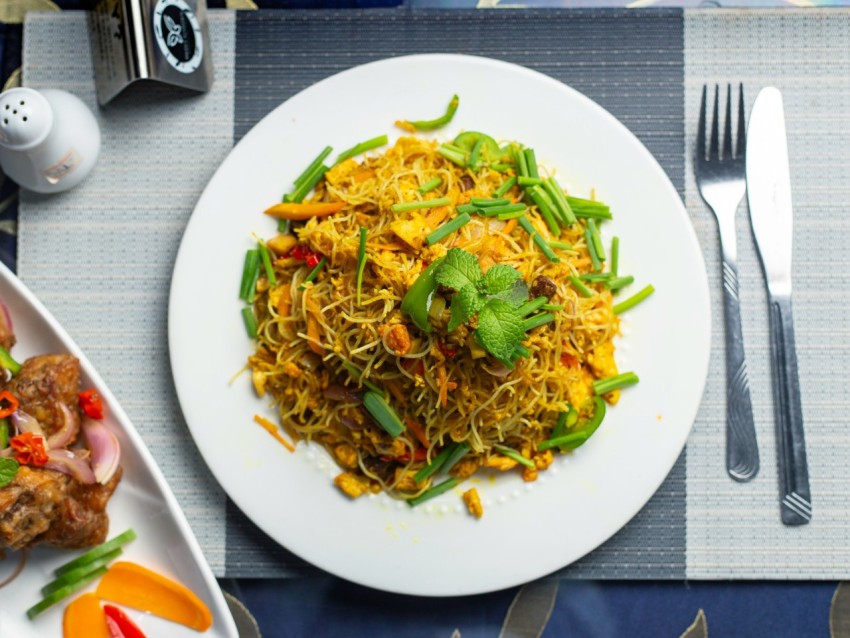 a white plate topped with food next to a fork and knife