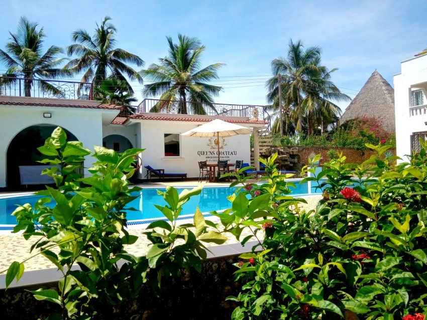 a hotel with a swimming pool surrounded by greenery