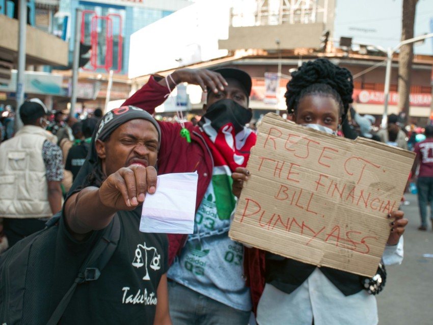 a group of people standing around each other holding a sign