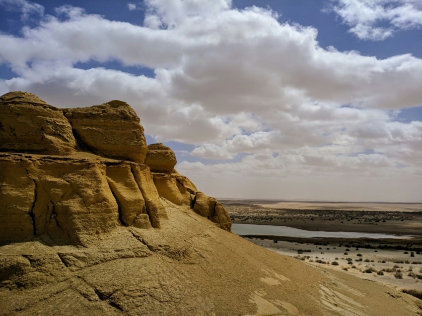 brown rock formation near body of water during daytime