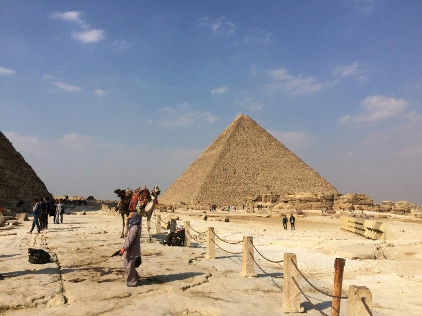 people standing near pyramid of giza under blue and white sky at during daytime c