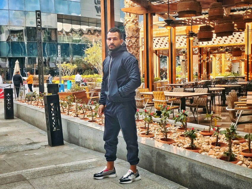 a man standing in front of a store filled with plants