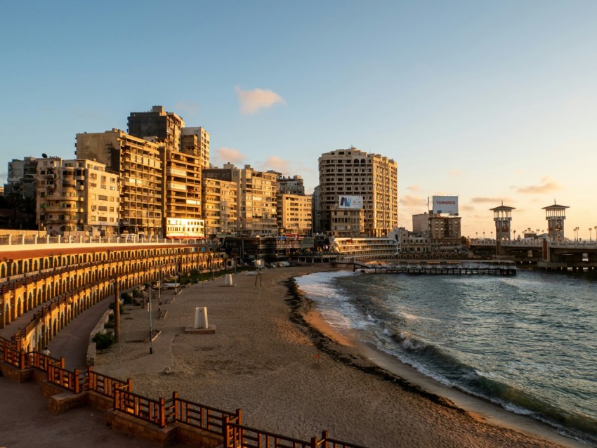 people walking on beach shore near high rise buildings during daytime E