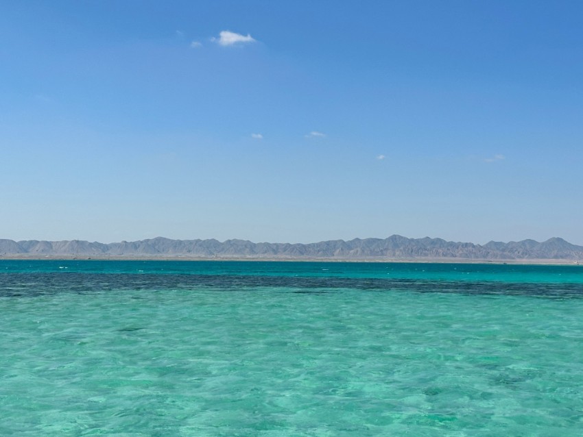 a large body of water with mountains in the background