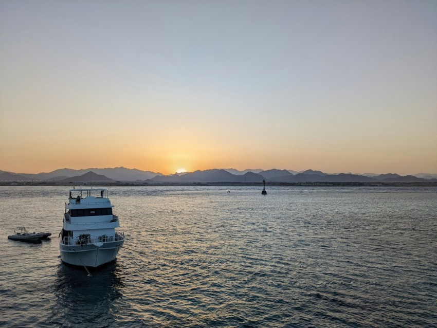 a white boat floating on top of a large body of water