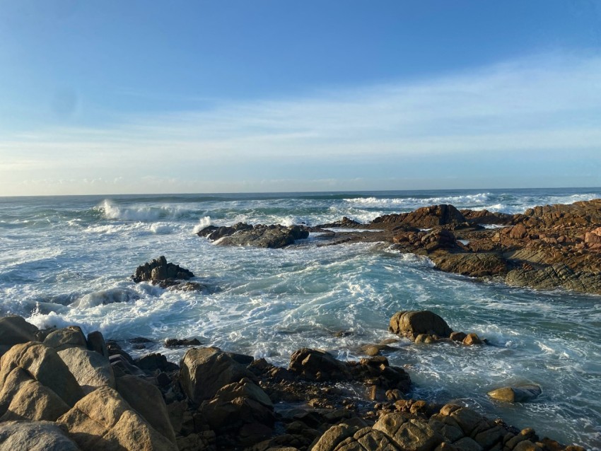 a rocky shore with waves crashing against the rocks