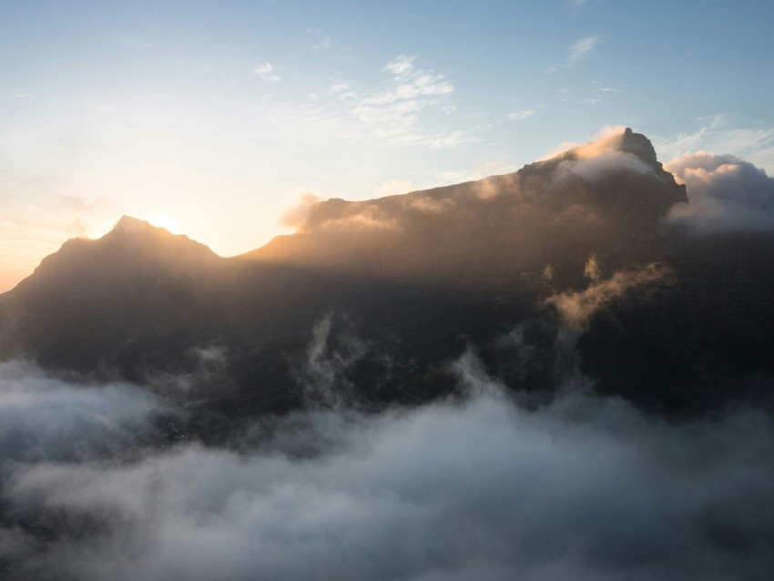 a view of a mountain covered in clouds