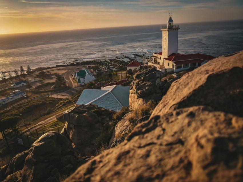 a lighthouse on top of a cliff near the ocean