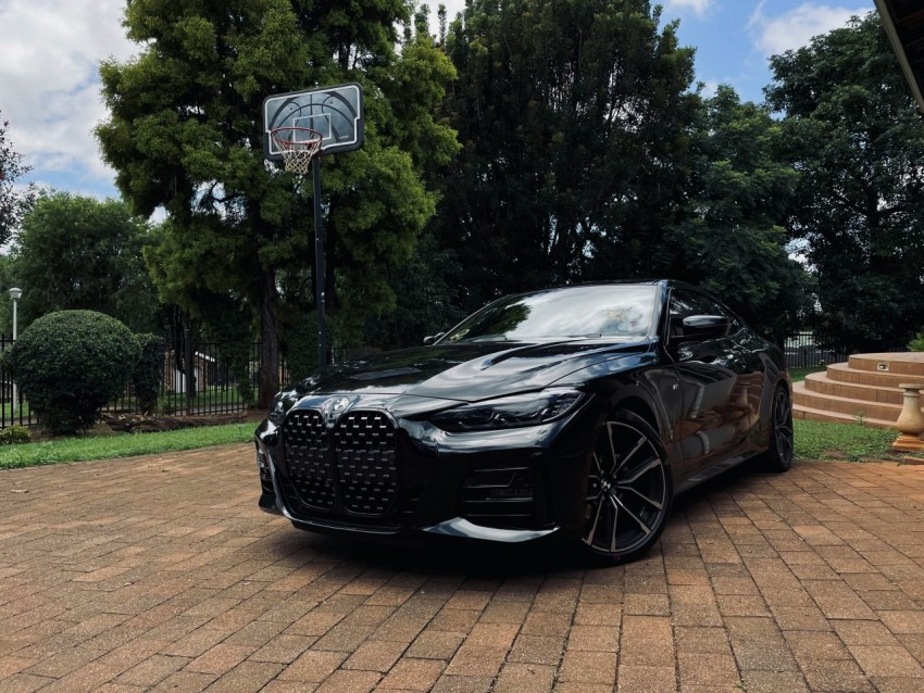 a black sports car parked in front of a basketball hoop