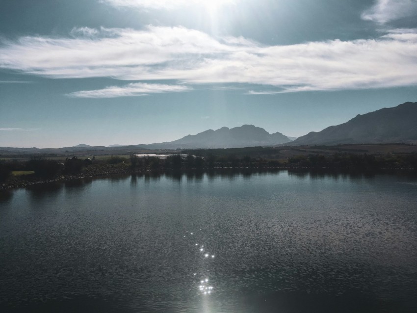 lake near mountain under blue sky during daytime