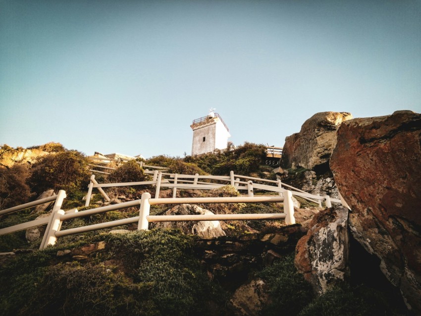 a white lighthouse on top of a hill