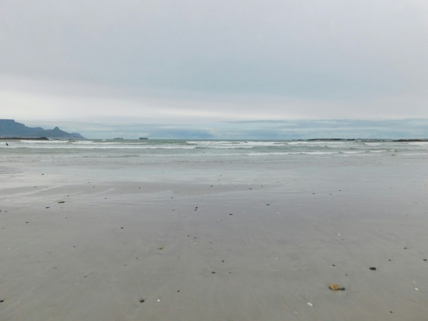 a sandy beach with waves coming in to shore